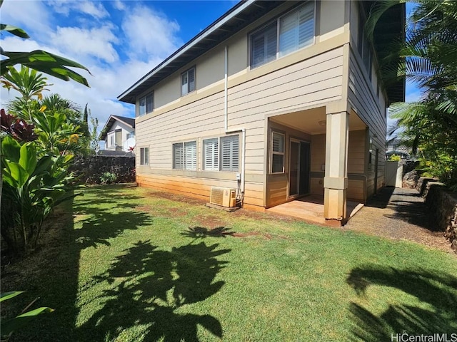 rear view of house featuring fence and a lawn