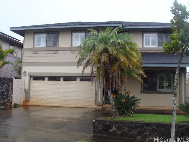 view of front of home featuring driveway, an attached garage, and stucco siding