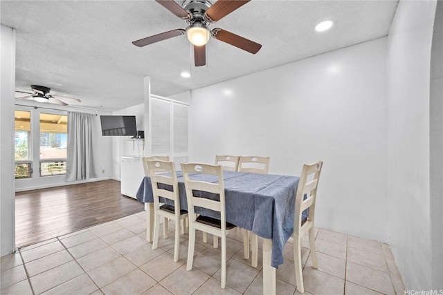 dining area with light tile patterned flooring, ceiling fan, and a textured ceiling