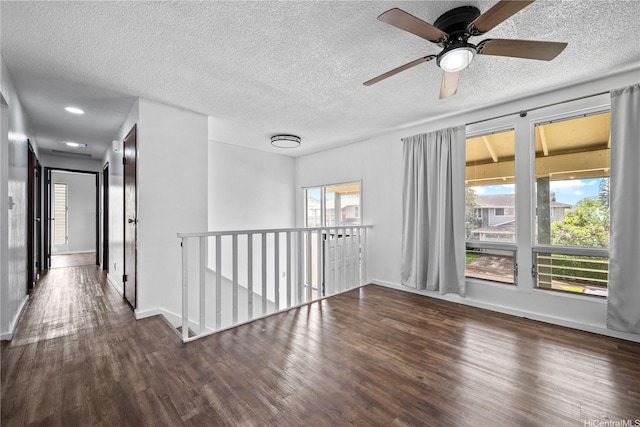 spare room with baseboards, a textured ceiling, ceiling fan, and wood finished floors