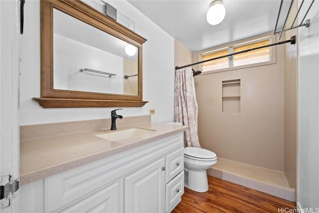 full bath featuring toilet, vanity, a shower with shower curtain, and wood finished floors