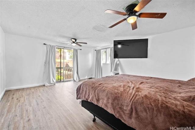 bedroom featuring ceiling fan, a textured ceiling, baseboards, and wood finished floors