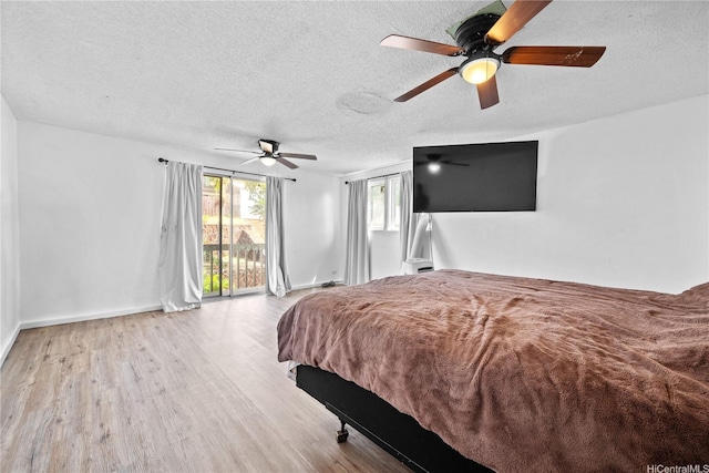 bedroom featuring baseboards, ceiling fan, a textured ceiling, and wood finished floors