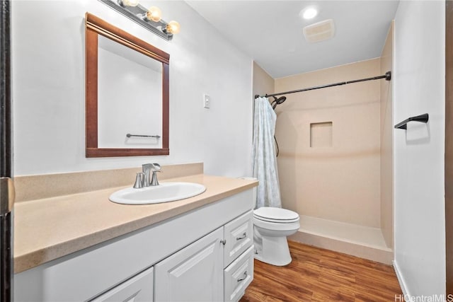 full bath featuring visible vents, toilet, a shower with curtain, wood finished floors, and vanity