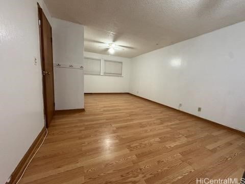 spare room with baseboards and wood finished floors