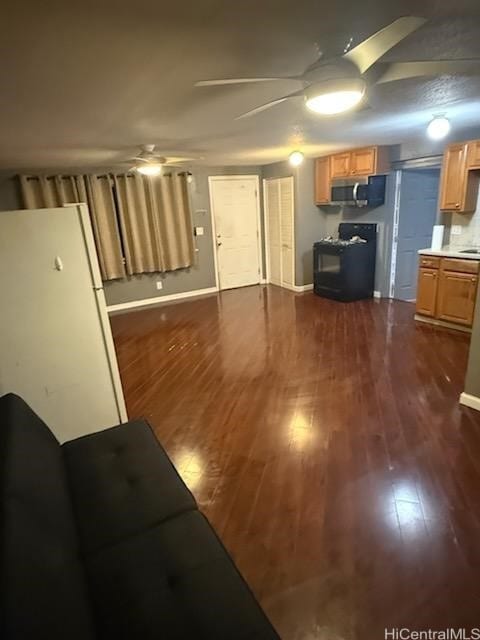 living area featuring baseboards, a ceiling fan, and dark wood-style flooring