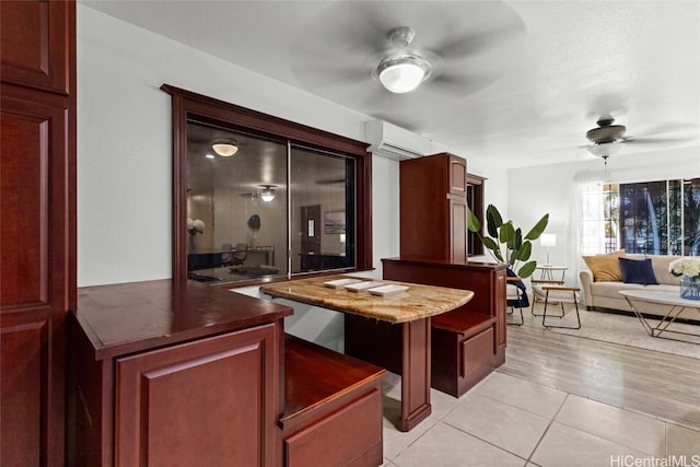 interior space featuring light tile patterned flooring, an AC wall unit, and ceiling fan