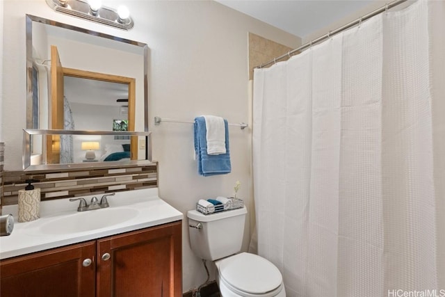 full bathroom with backsplash, toilet, and vanity