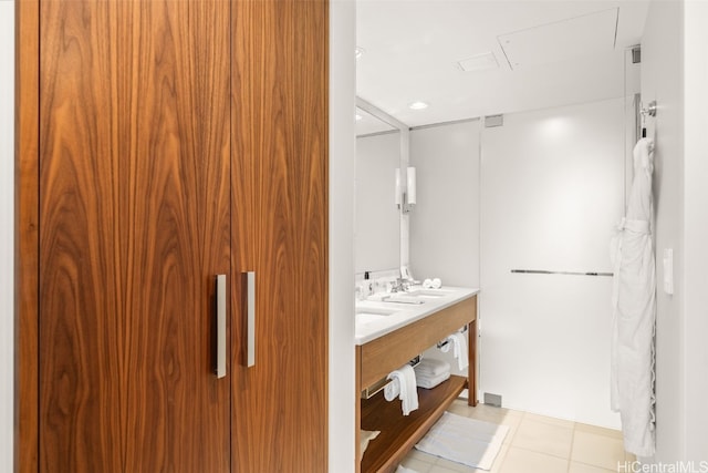 full bathroom featuring tile patterned flooring, double vanity, and a sink