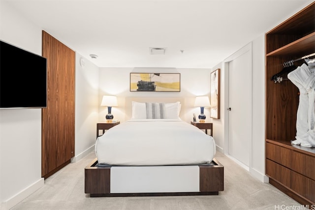 bedroom featuring visible vents, baseboards, and light colored carpet