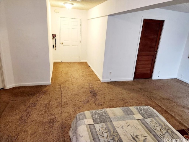 carpeted spare room featuring visible vents, a textured ceiling, and baseboards