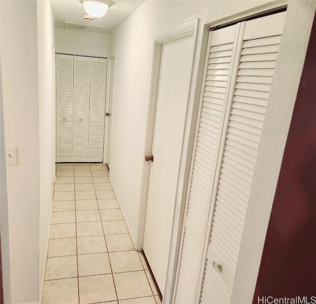 hall featuring light tile patterned flooring