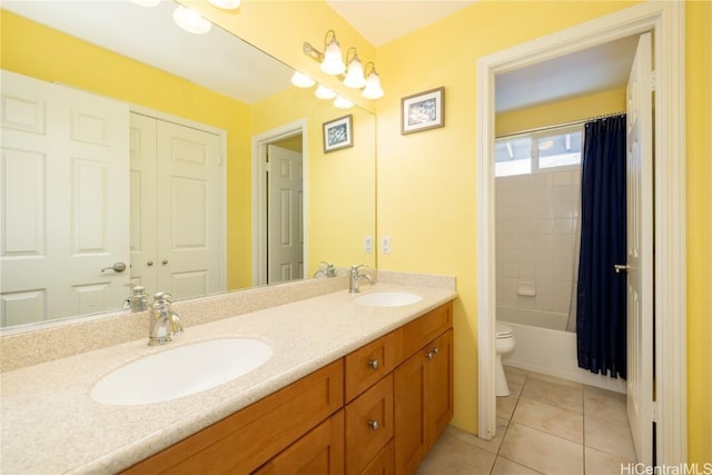 full bathroom with double vanity, tile patterned flooring, a sink, and toilet