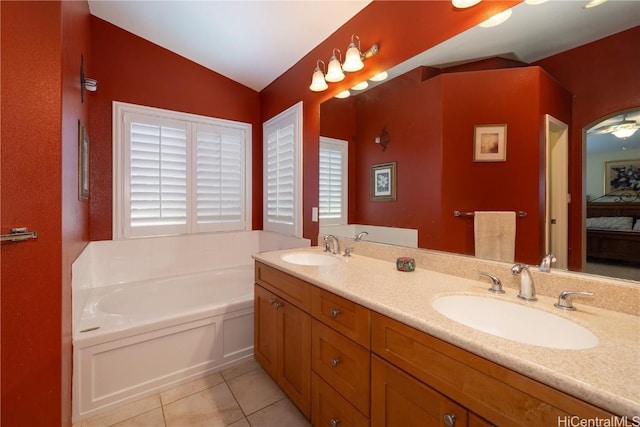 bathroom featuring ensuite bath, tile patterned flooring, a garden tub, and a sink