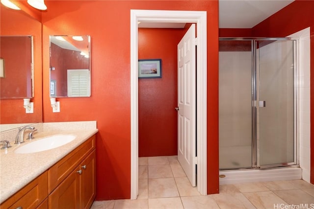 full bath with a stall shower, vanity, and tile patterned floors