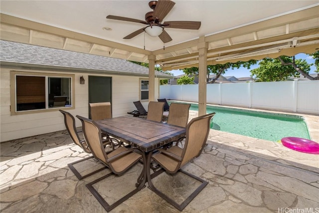 view of patio / terrace with outdoor dining area, fence, a fenced in pool, and a ceiling fan