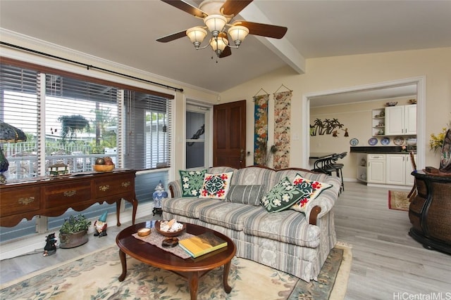 living room with a ceiling fan, vaulted ceiling with beams, and light wood-style floors