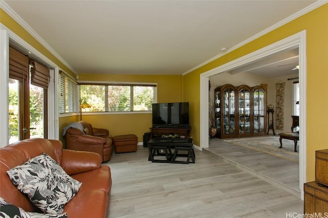 living room with light wood-type flooring, baseboards, crown molding, and french doors