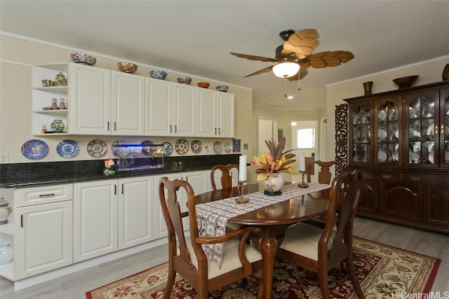 dining area featuring a ceiling fan, light wood-style floors, and ornamental molding