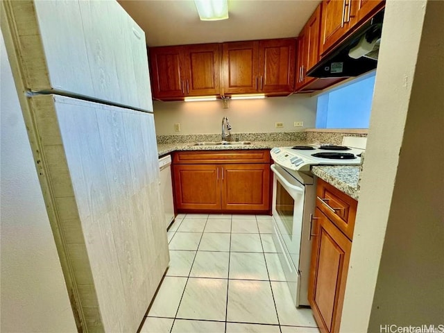 kitchen featuring light stone counters, light tile patterned flooring, a sink, white appliances, and under cabinet range hood