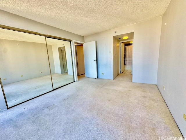 unfurnished bedroom featuring light colored carpet and a textured ceiling