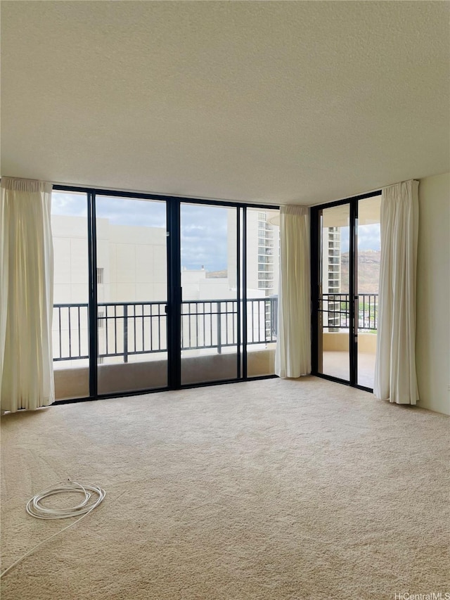 3130 Ala Ilima St Unit 18C, Honolulu, HI 96818 - carpeted spare room with a textured ceiling and floor to ceiling windows