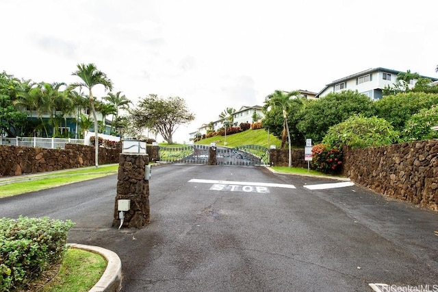 view of street featuring a residential view, a gate, curbs, and a gated entry