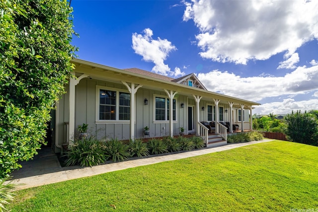view of front of house featuring a front lawn, board and batten siding, and covered porch