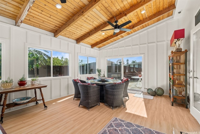 sunroom / solarium featuring a wooden deck, wood finished floors, wooden ceiling, lofted ceiling with beams, and a decorative wall