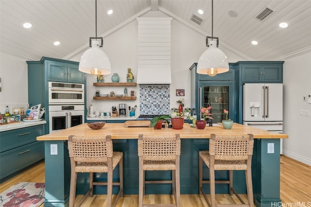 kitchen with white appliances, light wood-style flooring, visible vents, and wooden counters