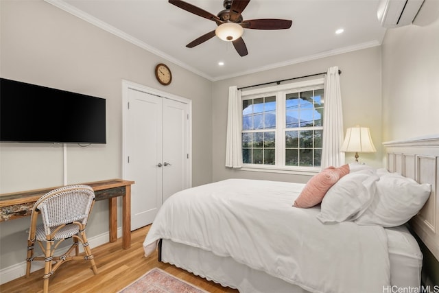 bedroom featuring light wood-type flooring, ornamental molding, a wall unit AC, recessed lighting, and a closet