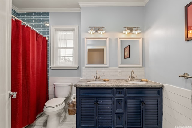 full bathroom featuring a sink, a wainscoted wall, and toilet