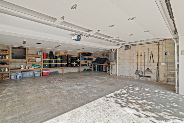 garage with concrete block wall and a garage door opener