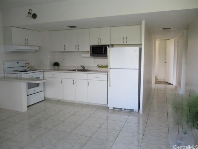 kitchen with white appliances, white cabinets, light countertops, under cabinet range hood, and a sink