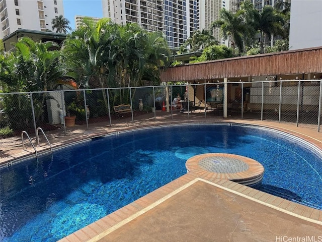 community pool with a patio and fence