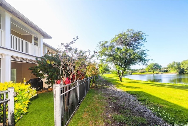 view of yard featuring a water view and fence