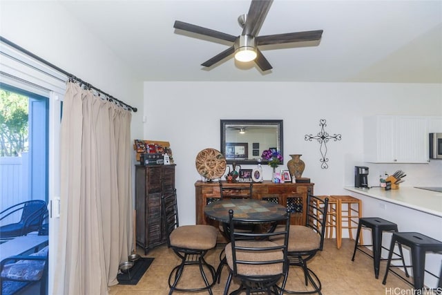 dining space with a ceiling fan and light tile patterned flooring