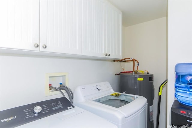 washroom with washer and dryer, electric water heater, and cabinet space