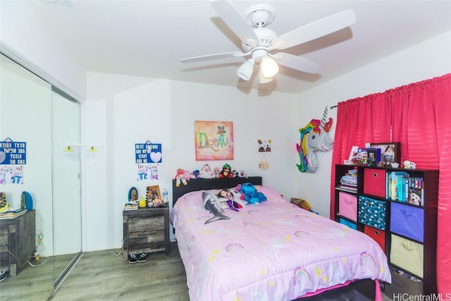 bedroom with a ceiling fan, a closet, and wood finished floors