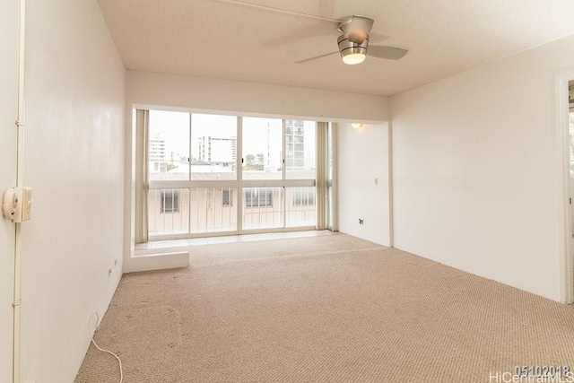 spare room featuring carpet and a ceiling fan