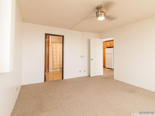 unfurnished room with light carpet and a textured ceiling