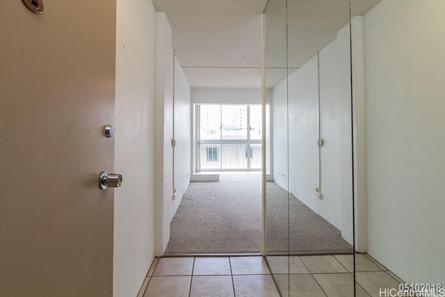 hallway featuring light carpet and light tile patterned flooring