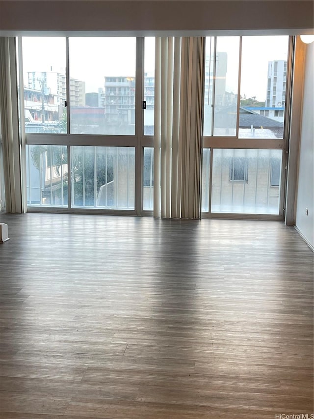 1710 Punahou St Unit 305, Honolulu, HI 96822 - unfurnished room featuring dark wood-style floors, plenty of natural light, and a view of city