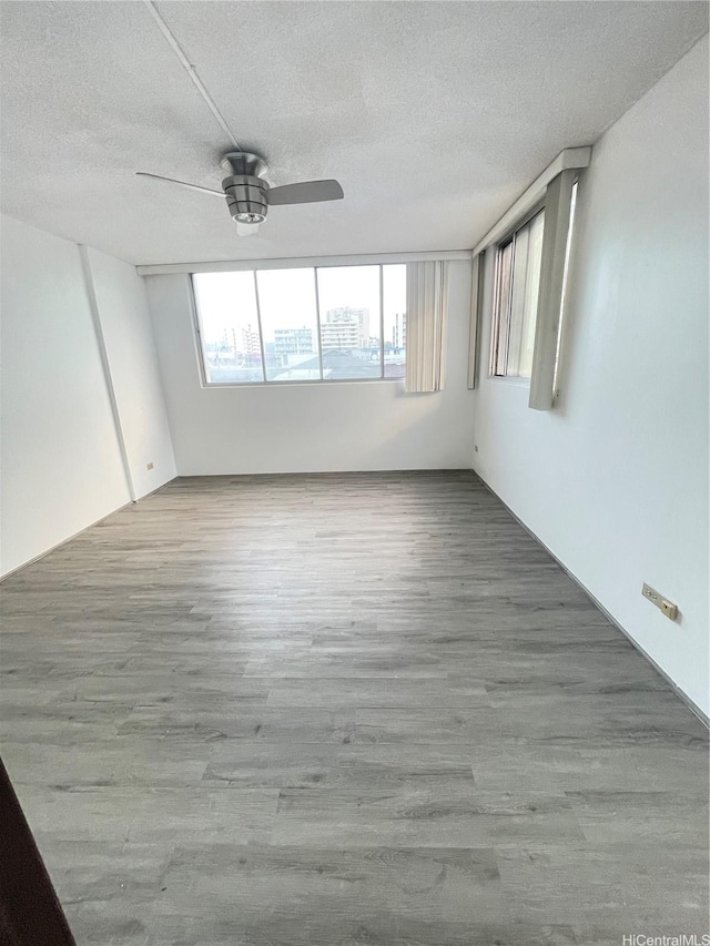 1710 Punahou St Unit 305, Honolulu, HI 96822 - spare room featuring wood finished floors, a textured ceiling, and a ceiling fan