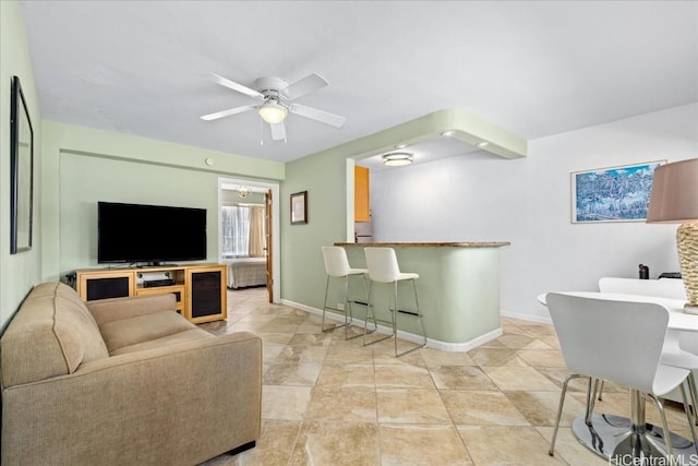 living room with light tile patterned flooring, baseboards, and a ceiling fan