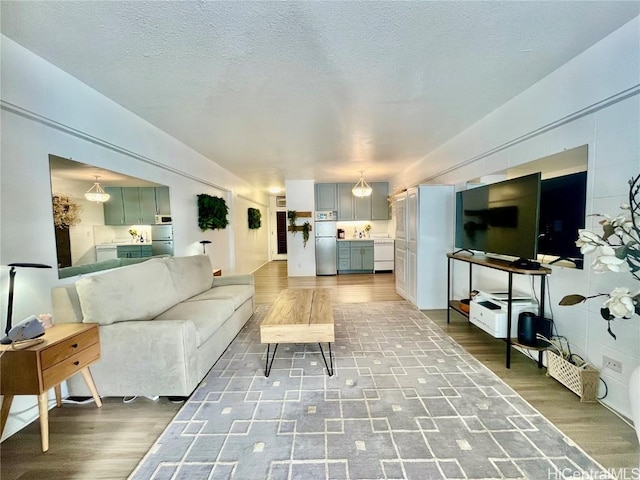 living area with a textured ceiling and wood finished floors