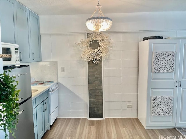 unfurnished dining area with tile walls, light wood-style floors, and a textured ceiling