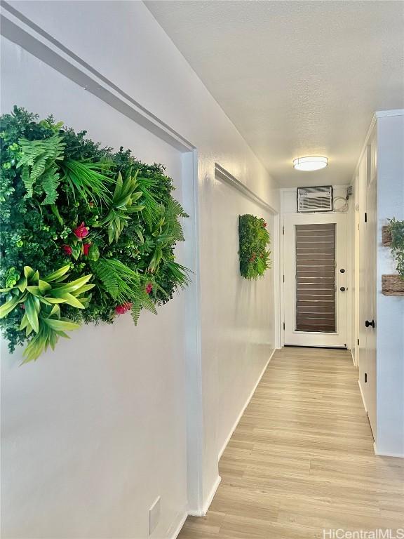 hall featuring a textured ceiling and light wood-type flooring