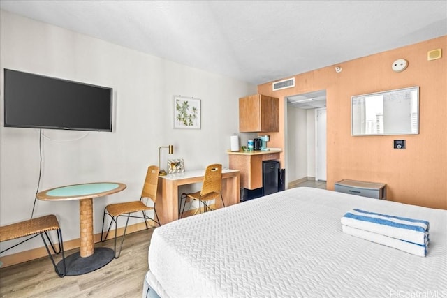 bedroom featuring baseboards, visible vents, and light wood-style floors