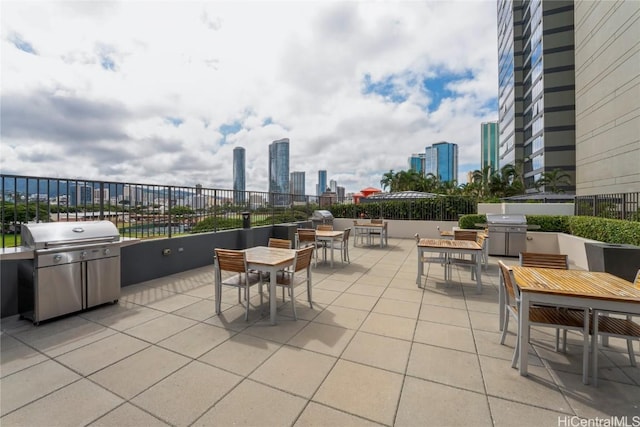 view of patio / terrace with a view of city, grilling area, and outdoor dining space